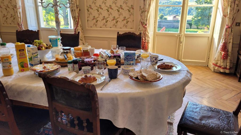 una mesa con comida, bebidas y platos de comida en Chateau Le Plessis, en Sémelay