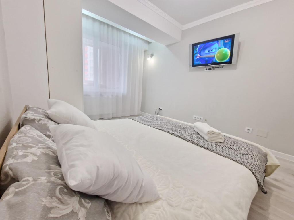 a bedroom with a bed with a tv on the wall at Gio Apartment in Chişinău