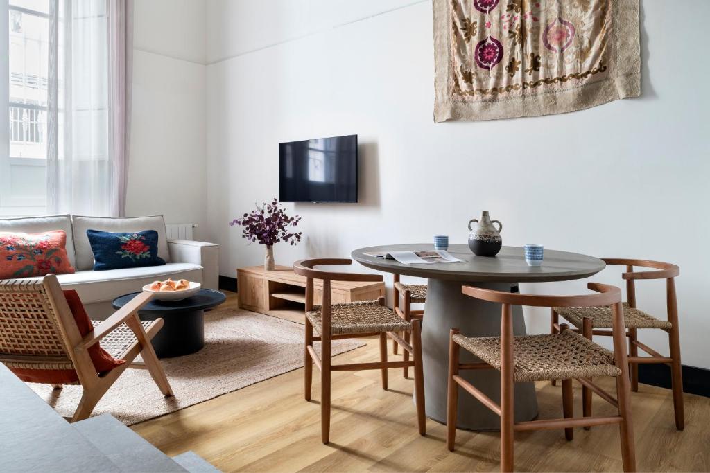 een woonkamer met een tafel en stoelen en een bank bij Tranquilo acogedor y céntrico 2beds & 2bath in Sevilla