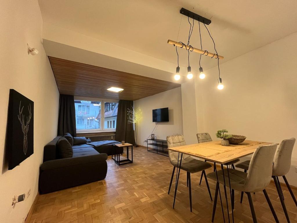 een woonkamer met een tafel en een eetkamer bij Simplex Apartments Am Schwabentor in Freiburg im Breisgau