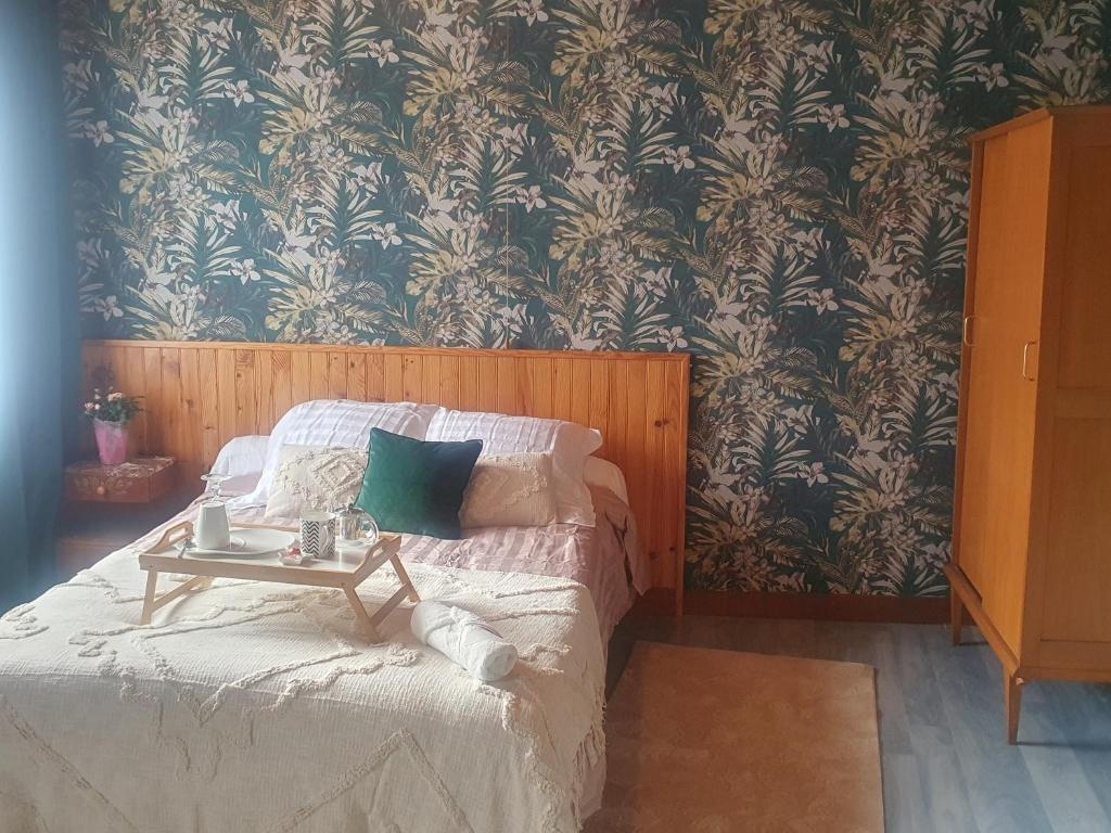 Un dormitorio con una cama con una mesa. en La Rosée - Studio Cosy à 50m des Thermes - Vue jardin, Wifi, Netflix, Smart TV, en Bourbonne-les-Bains