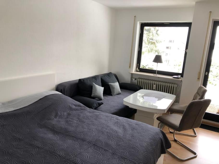 ein Schlafzimmer mit einem Bett, einem Sofa und einem Tisch in der Unterkunft Schwarzwald Apartment mit Terasse in Schönwald