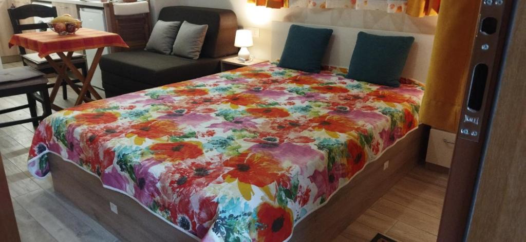 Un dormitorio con una cama con un edredón colorido. en Studio GALILEO, en Burgas