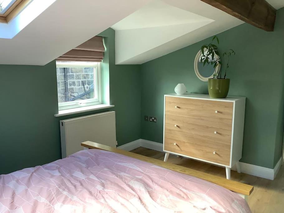a bedroom with a bed and a dresser and a window at Time House Cottage in Huby