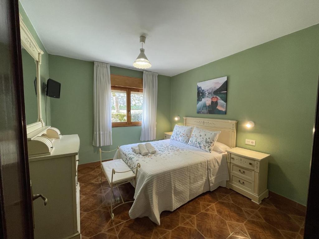 ein grünes Schlafzimmer mit einem Bett und einem Waschbecken in der Unterkunft La Ventana de Picos in Onís