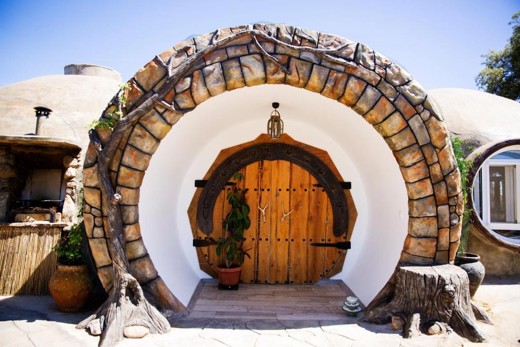a hobbit house with a wooden door at Casa Ballena, Finca La Lama Romana Bodonal de la Sierra in Bodonal de la Sierra