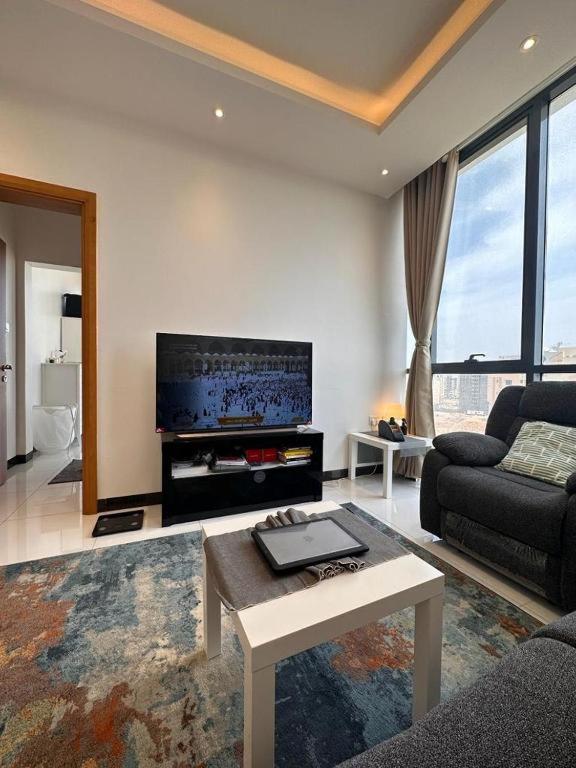 sala de estar con sofá y TV en Deluxe Flat, en Mascate