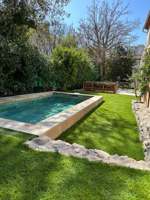 - une piscine dans une cour avec de l'herbe verte dans l'établissement Maison au calme au cœur du village de Mazargues - 7 personnes - Piscine, à Marseille