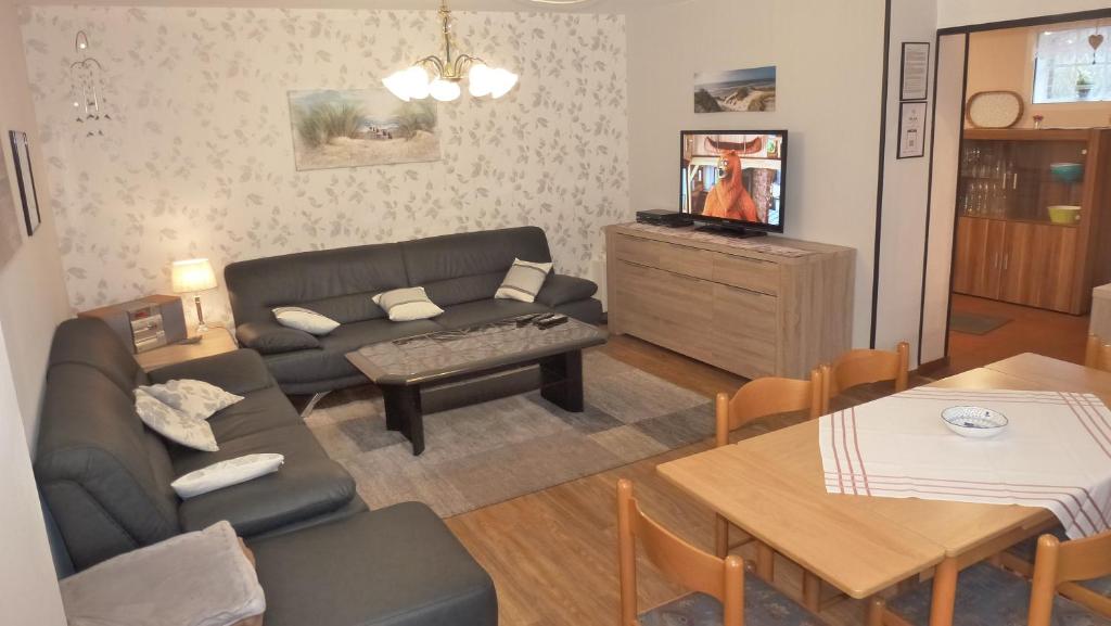 sala de estar con sofá y mesa en Ferienwohnung Petersen - Wohnung 1 en Uelvesbüll