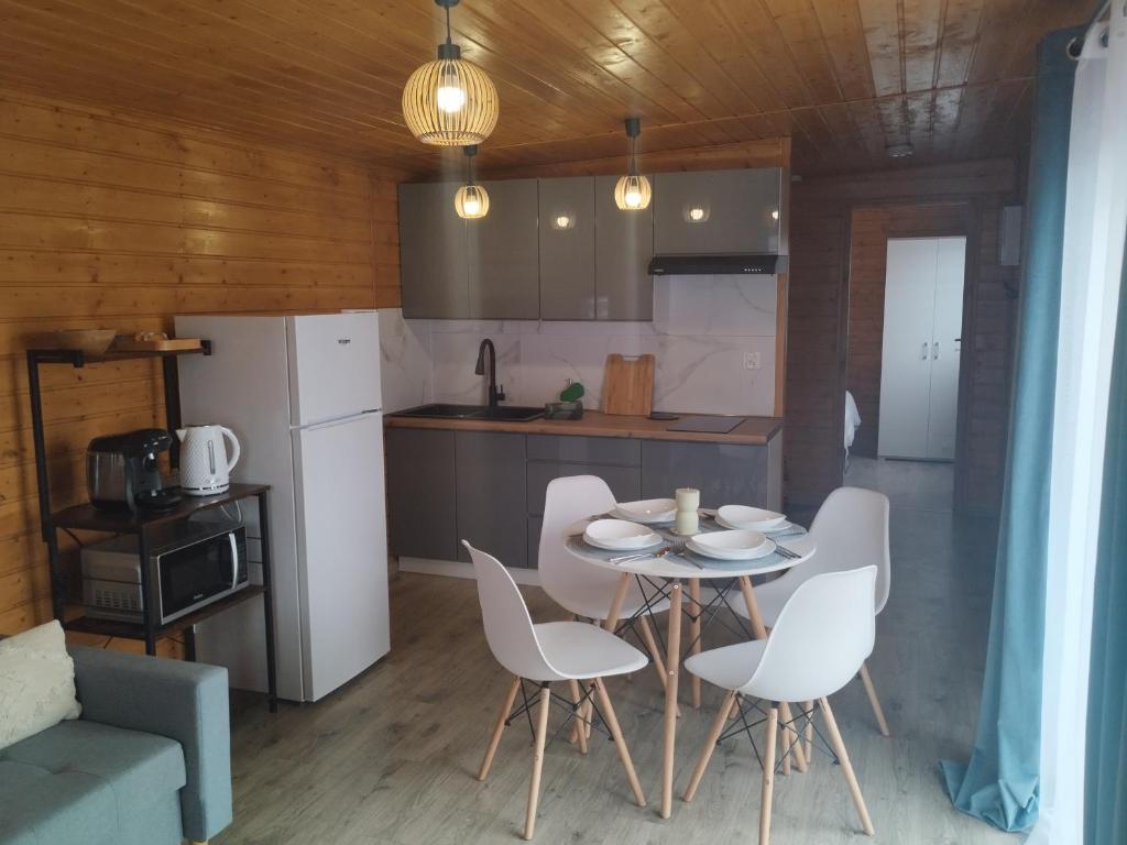 a kitchen and dining room with a table and chairs at Winiec Mobile Home in Miłomłyn