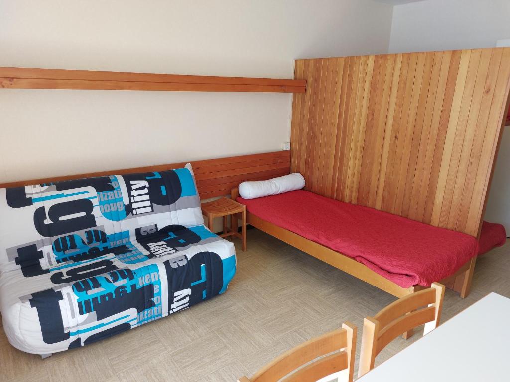 Cette petite chambre comprend un lit, une petite table et des chaises. dans l'établissement Studio Front de Neige, à Saint-Étienne-en-Dévoluy