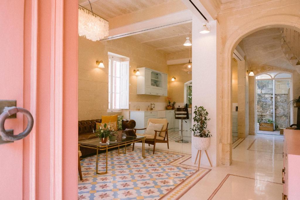 a living room with a table and a kitchen at Tinja Bnb in Sliema