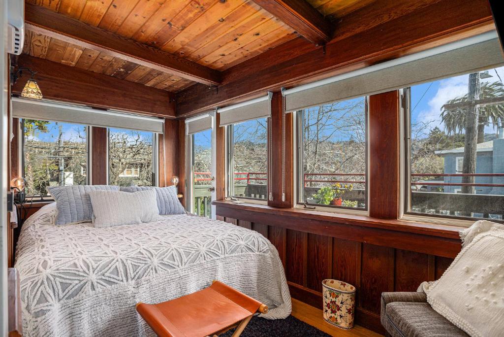 ein Schlafzimmer mit einem Bett in einem Zimmer mit Fenstern in der Unterkunft Maple Family Suite in Berkeley