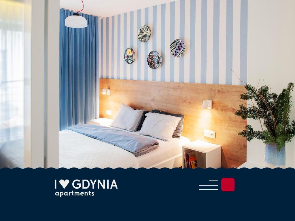 um quarto com uma cama com riscas azuis e brancas em I Love Gdynia Apartments - apartament z parkingiem em Gdynia