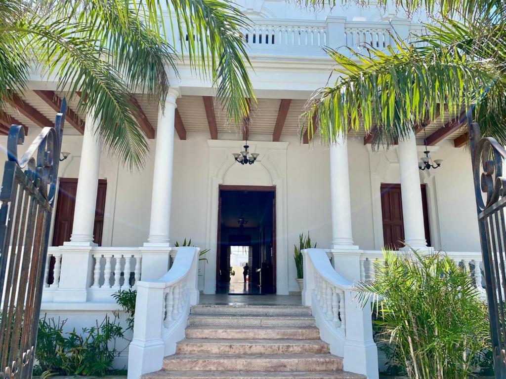 una escalera que conduce a una casa blanca con palmeras en Tecnohotel Casa Villamar en Progreso