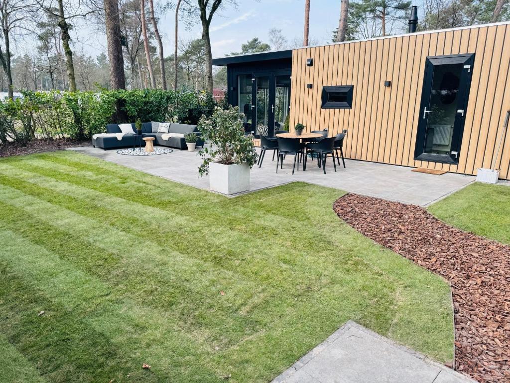 een tuin met een patio en een gazon bij Huisje in Stijl in Ermelo