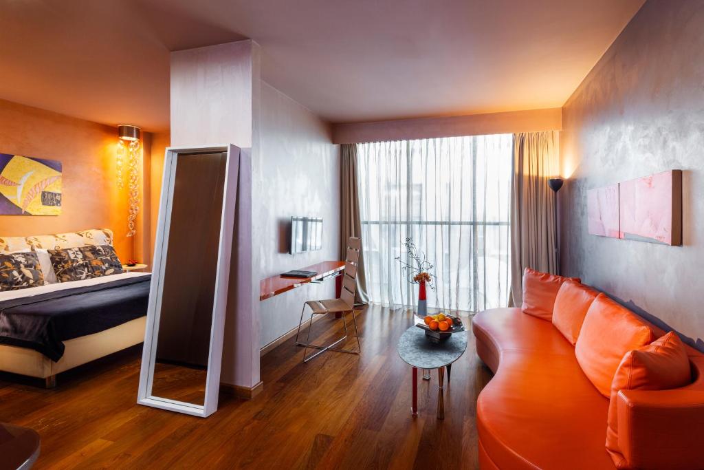 a bedroom with a couch and a bed and a mirror at Les Fleurs Boutique Hotel in Sofia