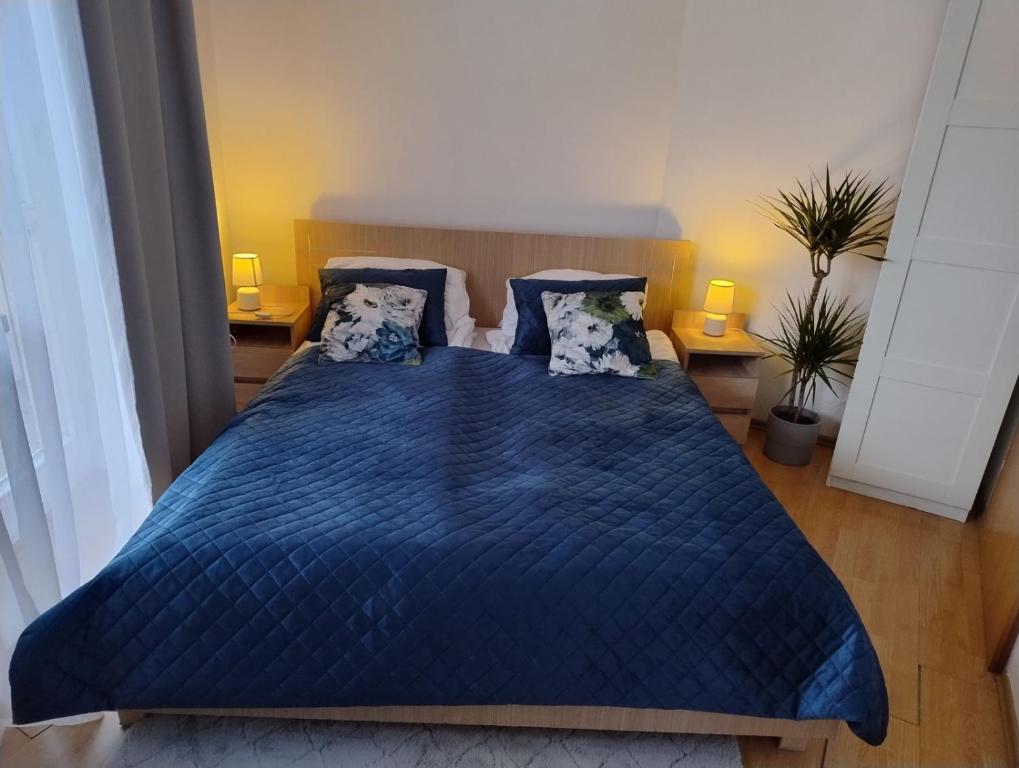 a bedroom with a blue bed with blue sheets and pillows at GreenApartament in Krakow
