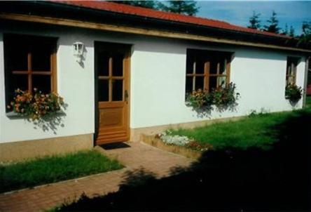 ein weißes Haus mit zwei Fenstern und einer Tür in der Unterkunft Ferienhäuser Börge in Sassnitz
