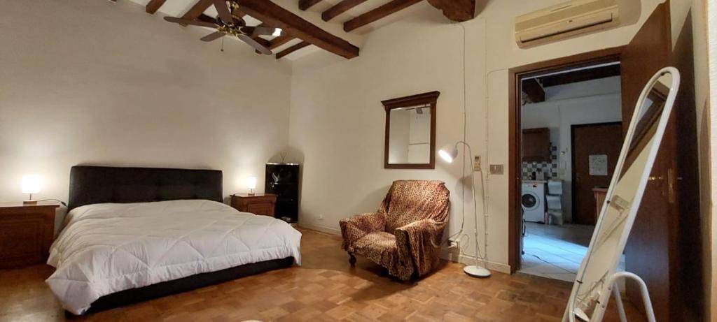 um quarto com uma cama, uma cadeira e uma janela em La Sosta-appartamento a pochi passi dalla stazione em Módena