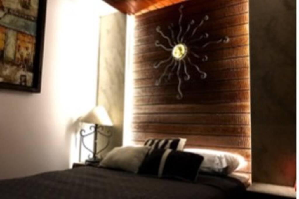 a bedroom with a wall with a clock on it at Lovely 1 downtown studio in Rosarito
