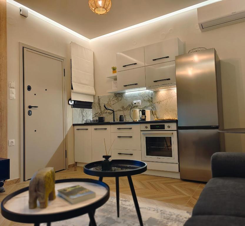 a kitchen with a stainless steel refrigerator and a table at Volos Guesthouse Konstantina in Volos