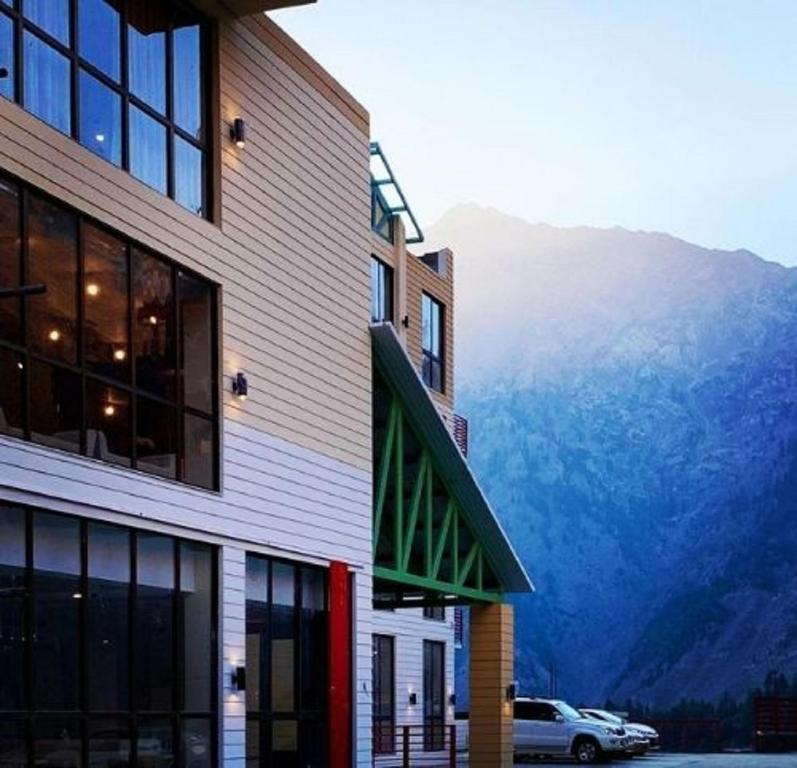 a building with a car parked in front of a mountain at The Sarai, Naran in Naran