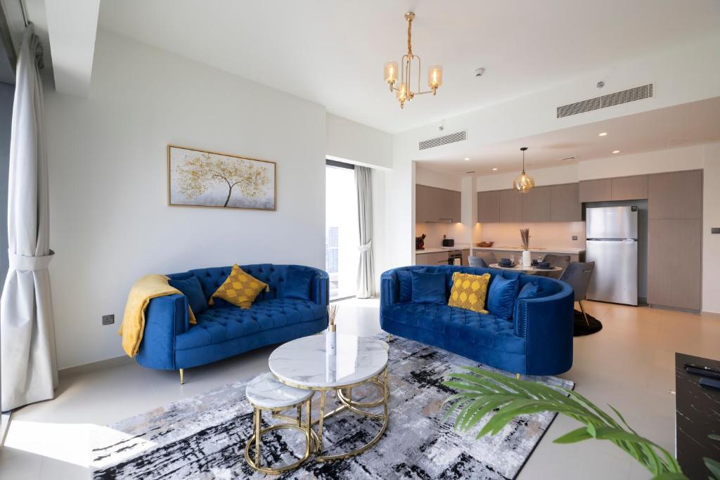 a living room with two blue couches and a table at Luxury 2-BR Apt with Burj View in Dubai