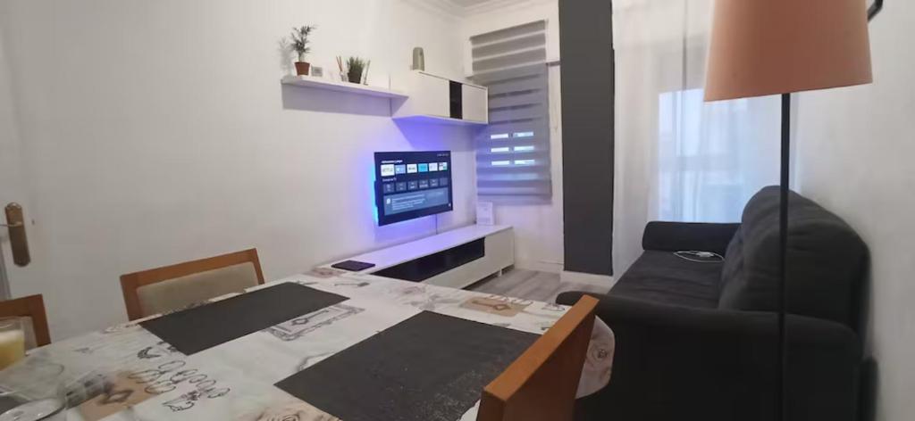 een kleine woonkamer met een tafel en een televisie bij Apartamento San Antón in Huesca