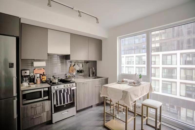 a kitchen with a table and a stove top oven at Brand New Studio in Heart of Downtown Toronto J8 in Toronto