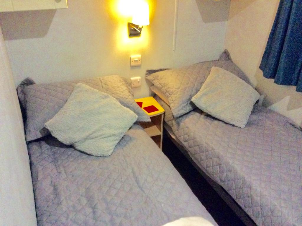 two beds sitting next to each other in a room at 2 Bedroom 6 Birth Caravan - Towyn in Abergele