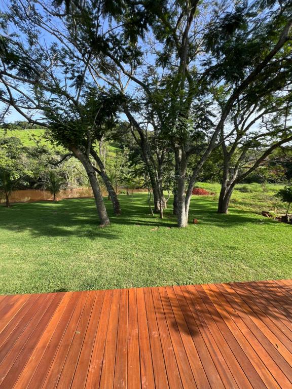 a wooden deck with trees in a park at Paraíso Capitólio Suítes Pousada in Capitólio