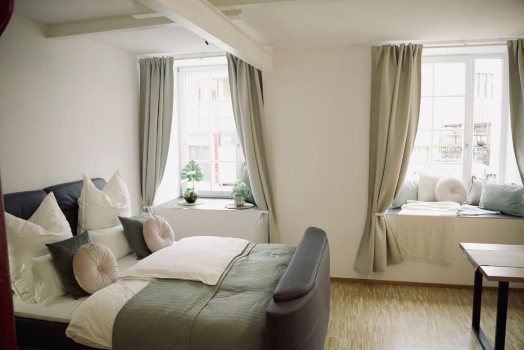 a bedroom with a bed and two windows at De la vie Reutlingen - Altstadt Apartment an Stadthalle & am Marktplatz in Reutlingen