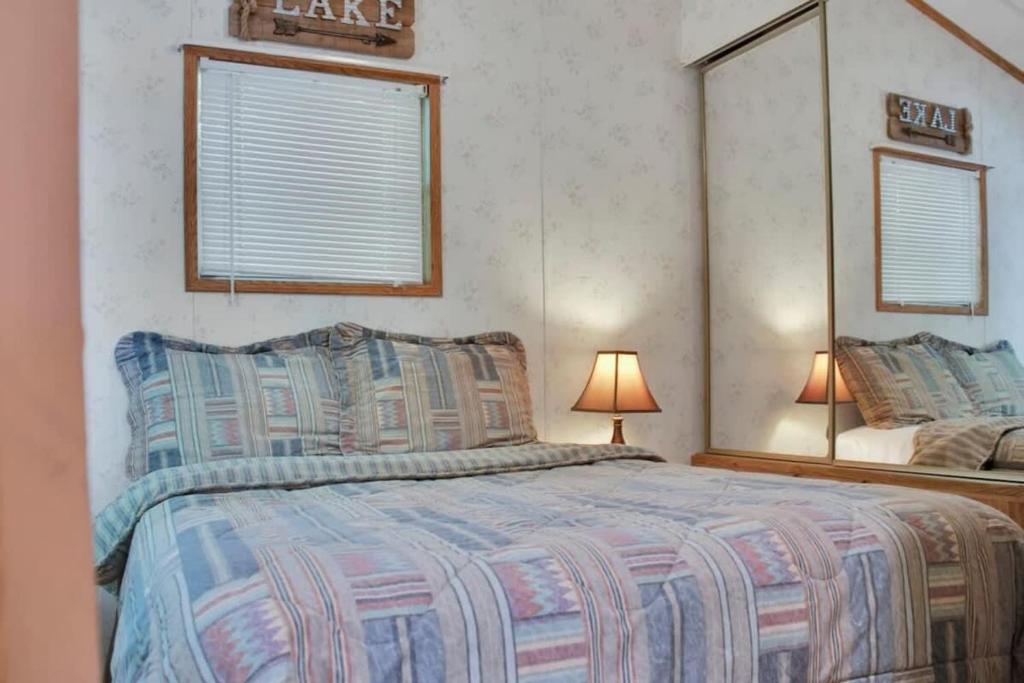 a bedroom with a large bed and a mirror at Lake Monroe's Charming Villa in Bloomington