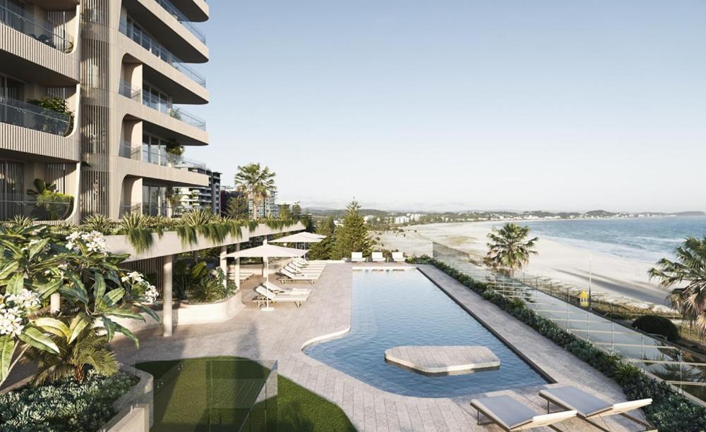CoolangattaにあるKirra Point Holiday Apartmentsのスイミングプールとビーチのあるリゾートの空からの景色を望めます。
