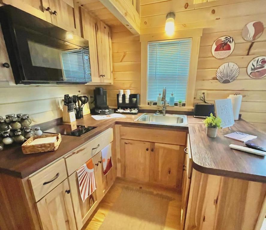 uma cozinha com armários de madeira e um lavatório em Charming Cabin near Ark Encounter with Loft em Dry Ridge