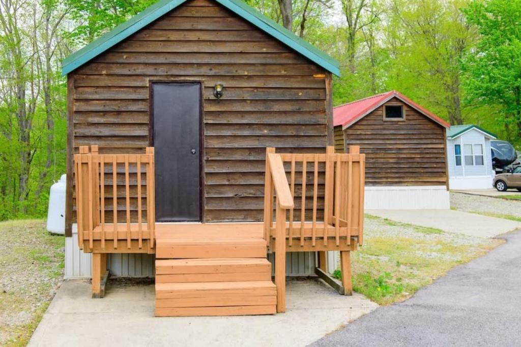 Dos sillas sentadas afuera de una cabaña de madera. en Homey Cabin in Bloomington with Views, en Bloomington