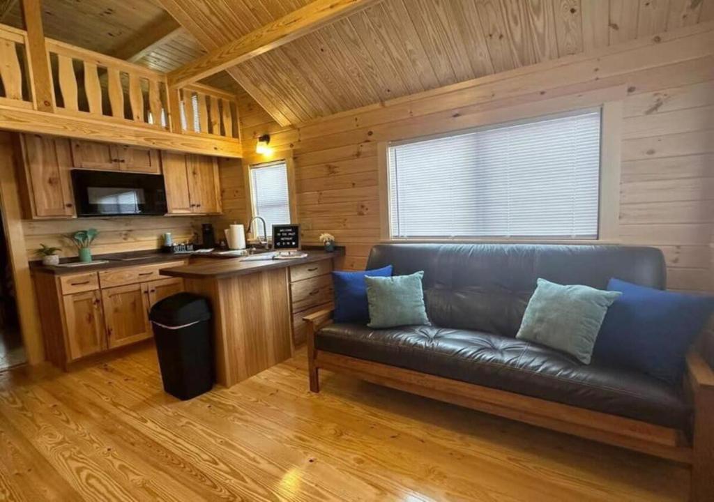 ein Wohnzimmer mit einem Sofa und einer Küche in der Unterkunft Get-away Cabin in Surf City w Loft and Parking in Surf City