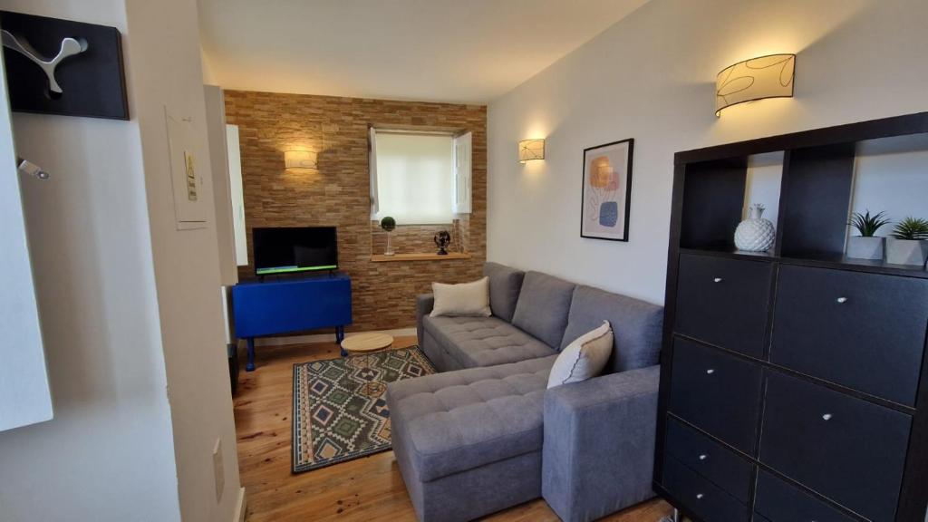 a living room with a couch and a television at Casa da Fonte in Sintra