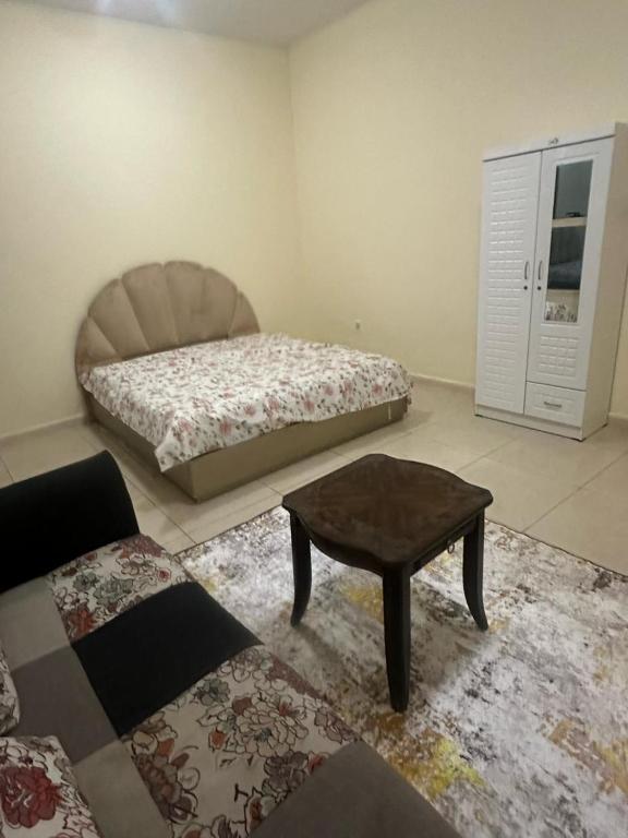 Schlafzimmer mit einem Bett und einem Couchtisch in der Unterkunft Furnished Beautiful Room For Stay in Ajman 