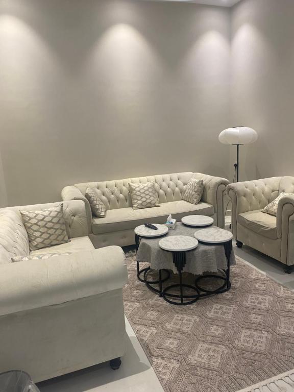 ein Wohnzimmer mit 2 Sofas und 2 Tischen in der Unterkunft غرفتين بدخول ذاتي in Al Kharj