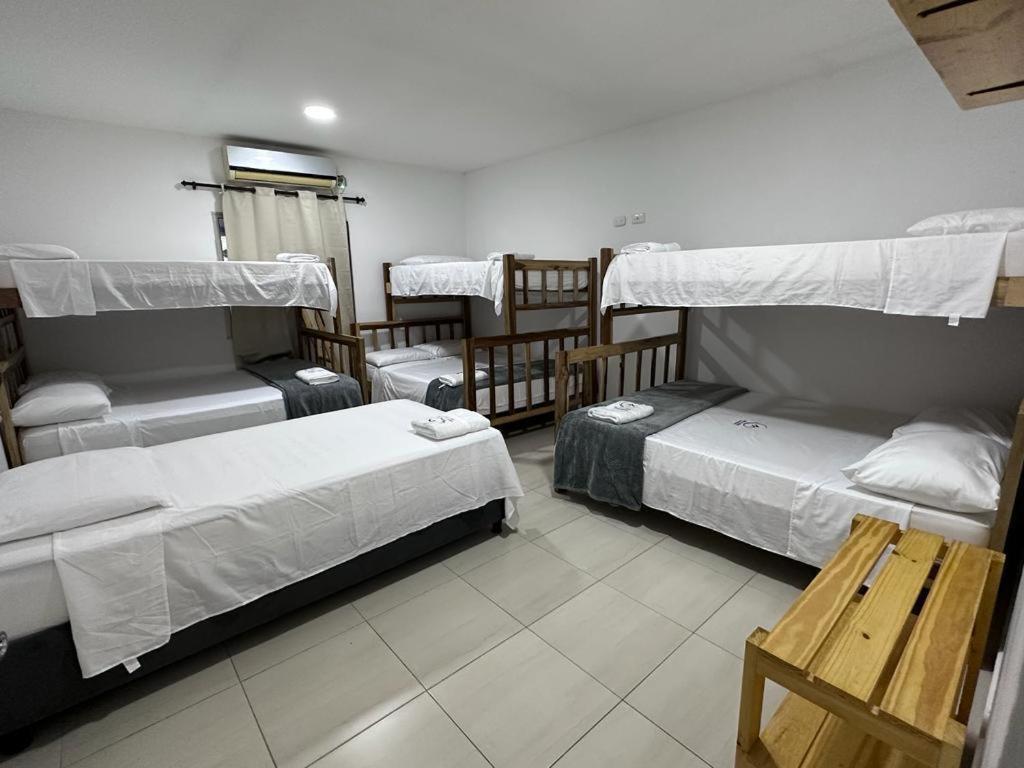 Habitación con 4 camas y mesa. en CABAÑA DE LUJO EN SABANGRANDE, en Sabanagrande