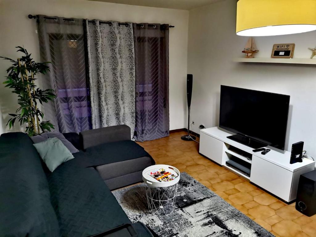 a living room with a couch and a flat screen tv at Chill House in Figueira da Foz