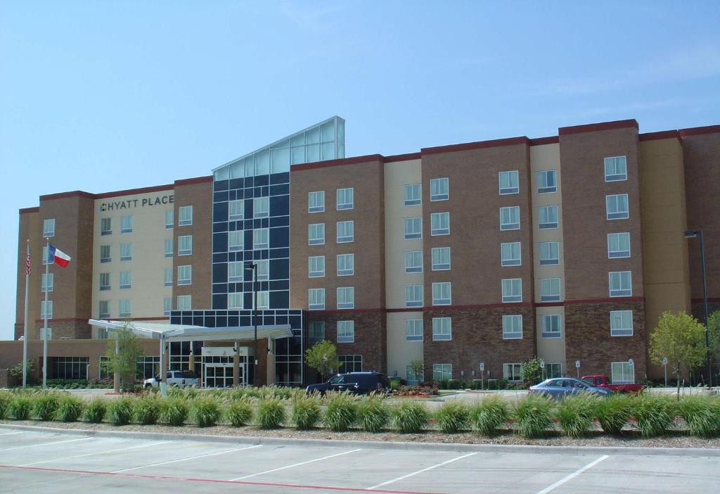 un gran edificio de ladrillo con un estacionamiento delante de él en Hyatt Place Dallas/Garland/Richardson, en Garland