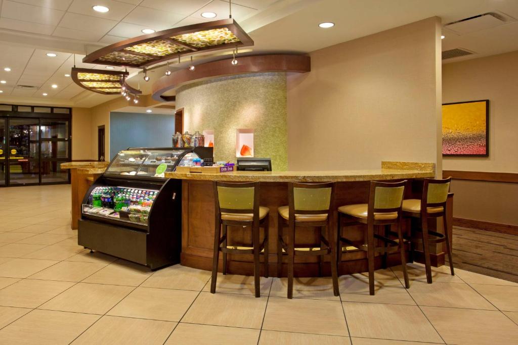 un restaurante con un bar con taburetes alrededor en Hyatt Place Fort Worth / Cityview, en Fort Worth