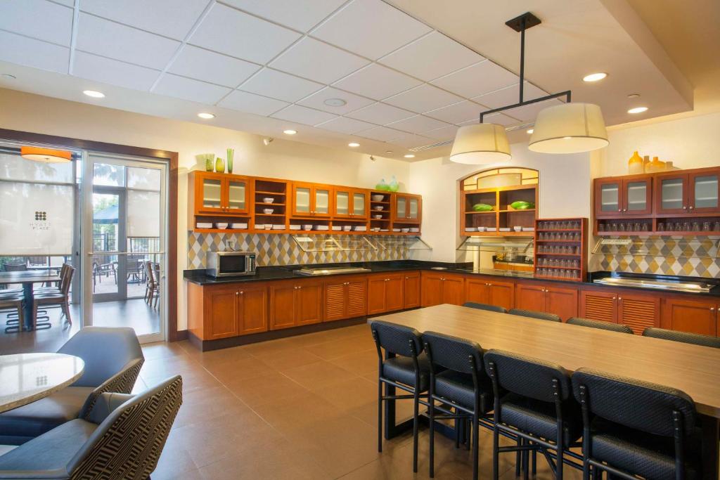 a large kitchen with a wooden table and chairs at Hyatt Place Lake Mary/Orlando North in Lake Mary