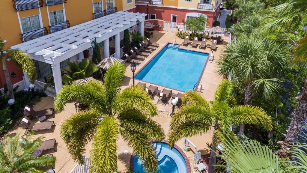 an aerial view of a hotel with a pool and palm trees at Hyatt Place Coconut Point in Estero