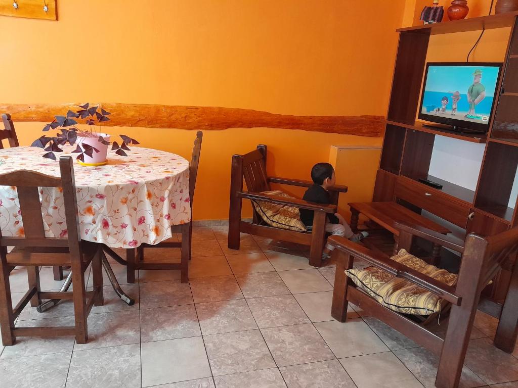 comedor con mesa, sillas y TV en alemdepartamentos2 en Ushuaia