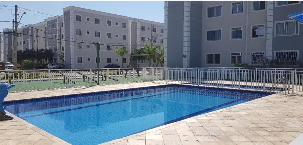une piscine en face d'un bâtiment dans l'établissement HollydayAppartment no Centro Rio das Ostras, à Rio das Ostras