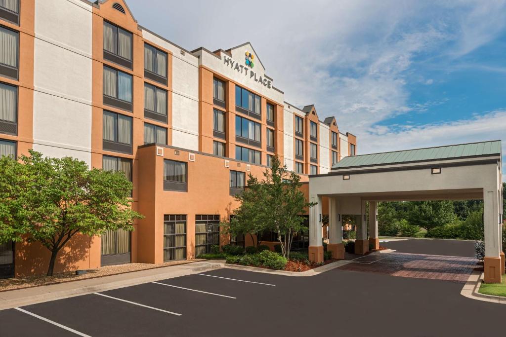 uma vista exterior de um hotel com estacionamento em Hyatt Place Rogers/Bentonville em Rogers